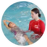 girl swimming on back in pool with Montana Swim Academy instructor assisting